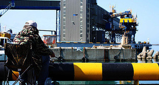 Рыбак на фоне погрузочного причала Туапсинского балкерного терминала. 15 мая 2010 года. Фото "Кавказского Узла"