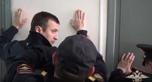 Задержанного Османа Хасбулатова осматривают перед заключением в камеру. Фото: кадр  видео пресс-службы  МВД. https://мвд.рф