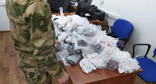 Сотрудник СКР рядом с партией изъятых веществ. Фото: пресс-служба СУ СКР по Ингушетии https://ingushetia.sledcom.ru/news/item/1526080/