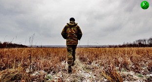 Военный идет по полю. Иллюстрация создана "Кавказским узлом" с помощью ИИ в программе Photoshop