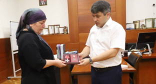 Передача награды матери убитого бойца. Скриншот фото из Telegram-канала Магомеда Курбанова от 20.08.25, https://t.me/mkurbanov/7083?single.